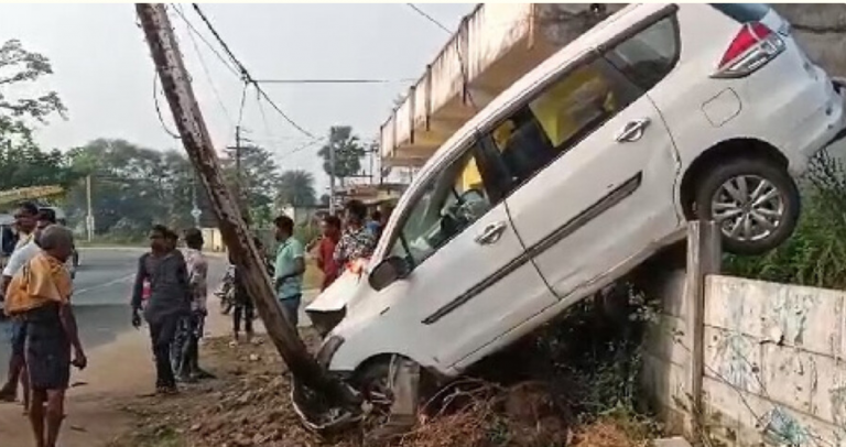 Car Hangs Off Boundary Wall After Crashing Into Pole In Odisha’s Balangir, Driver Safe