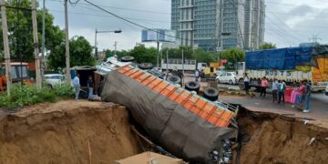 Road caves in, truck falls in crater