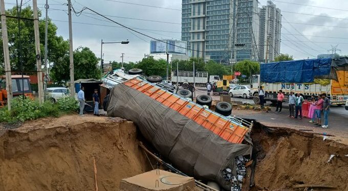 Road caves in, truck falls in crater
